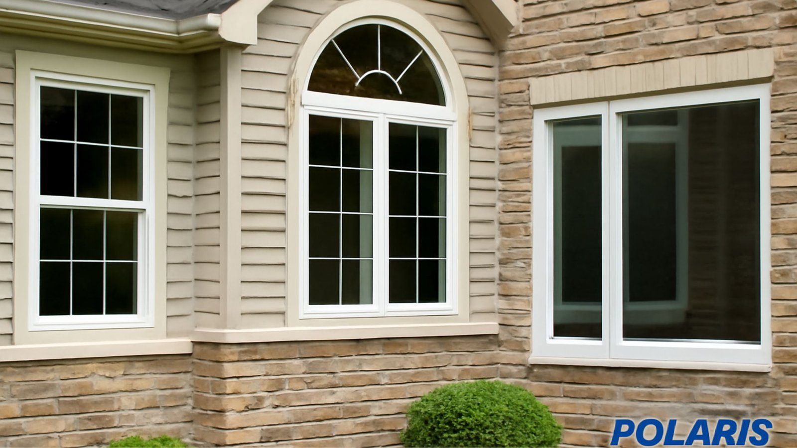 lose-up of two elegant white windows with grid patterns, placed on a stone-clad exterior wall of a house. The lower part of the image shows the "POLARIS" brand logo.